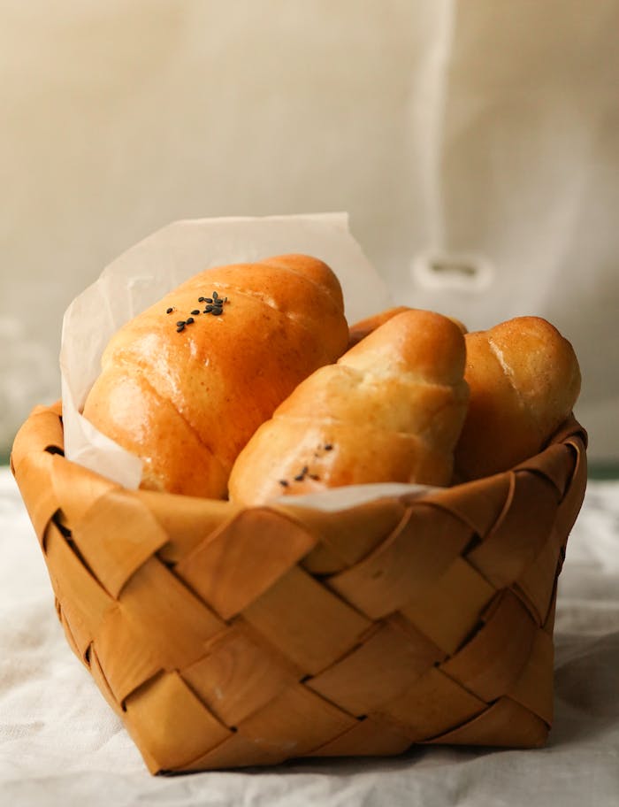 about-01 Close-up of freshly baked croissants in a woven basket, ideal for food presentations.